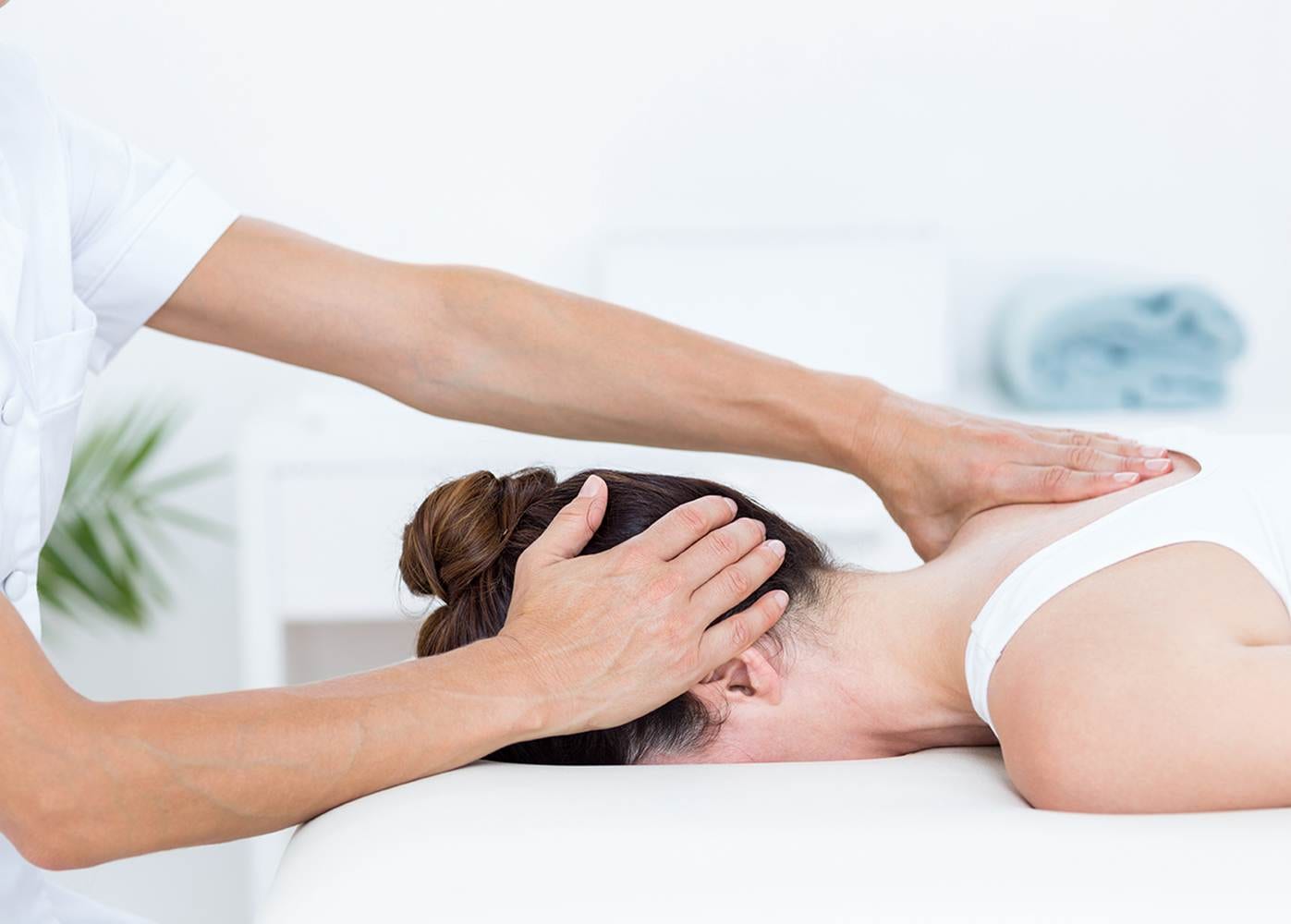 Physiotherapist doing neck massage in medical office